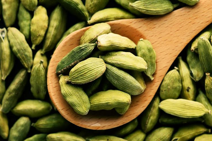 Premium cardamom pods in wooden bowl